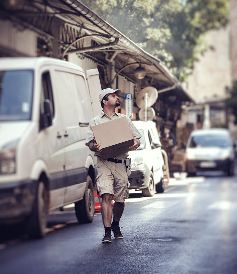 delivery man walks near van on street